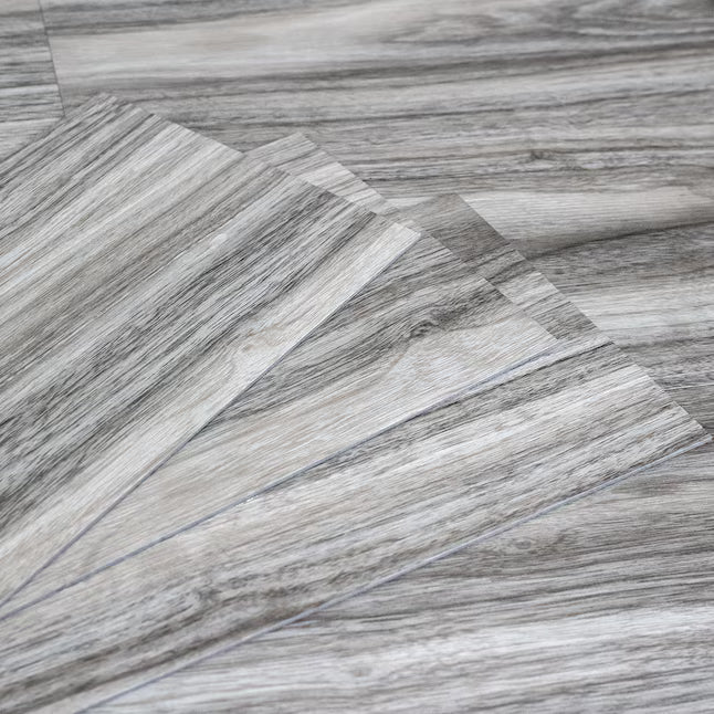 Gray wood-look vinyl flooring planks shown in a fanned-out arrangement to display the texture and grain pattern.